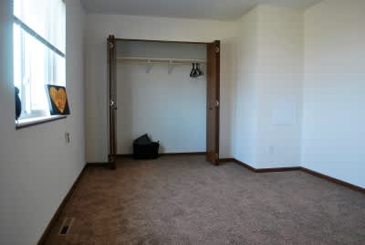 A room with a carpet floor and a white wall.