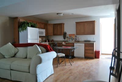 A kitchen with a white couch and wooden cabinets.