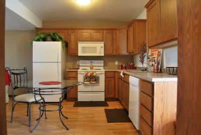 A kitchen with wooden cabinets and a white refrigerator.