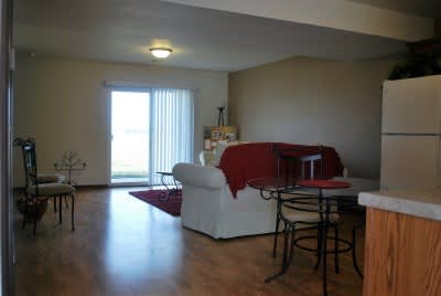 A living room with a white couch and a red throw.