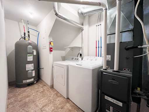 A water heater and a washing machine in a utility room.