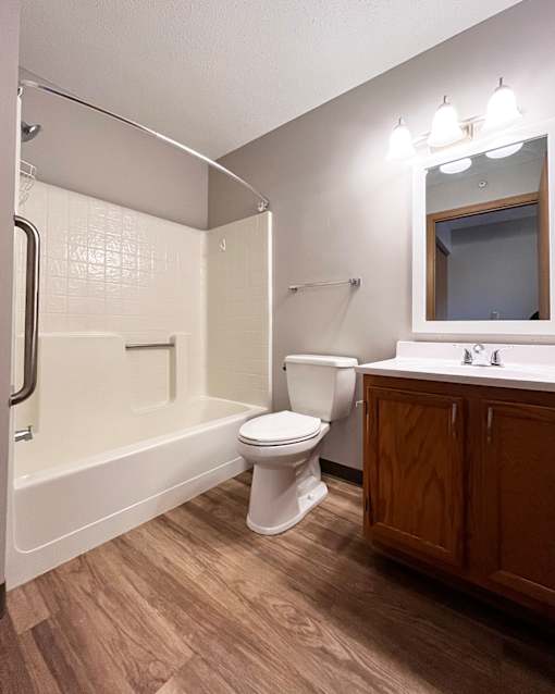 A white toilet sits next to a bathtub in a bathroom.