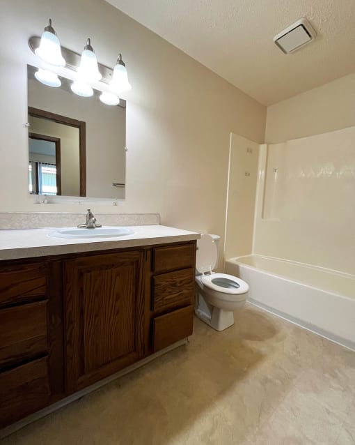 the interior of a bathroom with a sink toilet and mirror