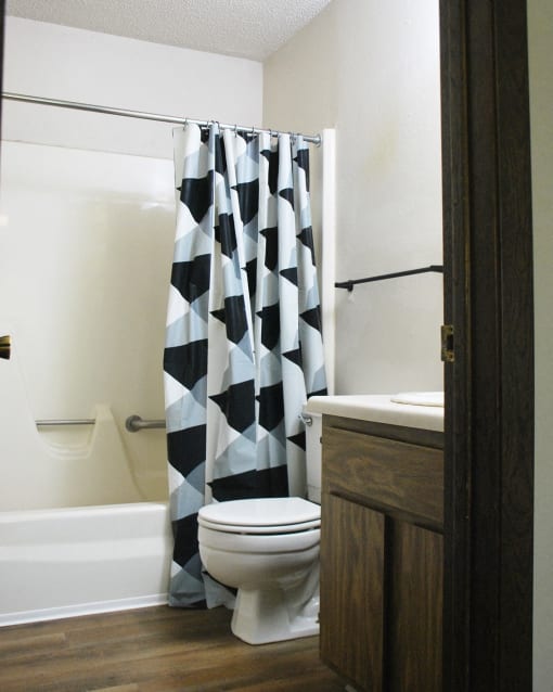 a bathroom with a black and white shower curtain and a toilet