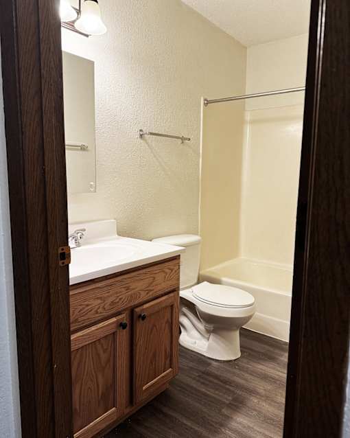 A white toilet sits in a bathroom next to a sink.