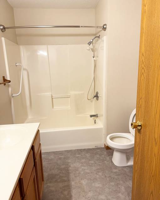 A white bathroom with a toilet, tub, and sink.