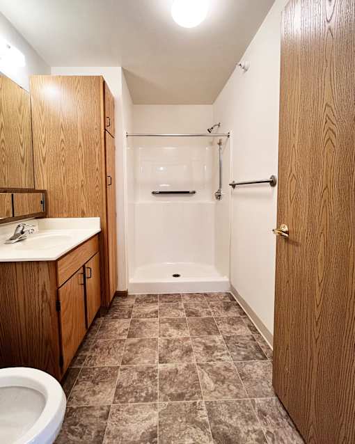 A bathroom with a toilet, sink, and shower.