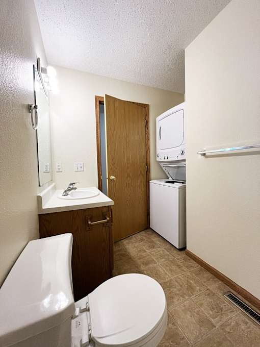 a bathroom with a toilet sink and a washer and dryer