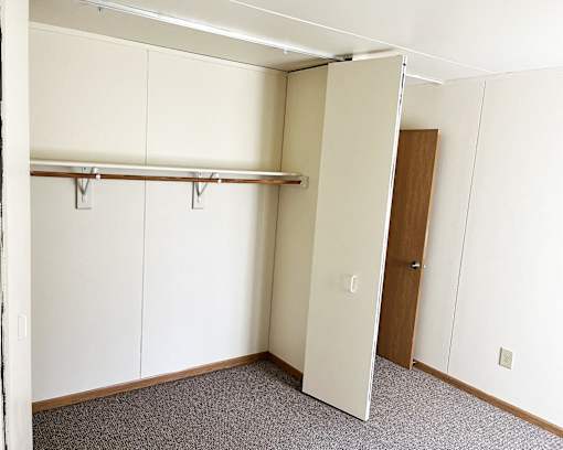an empty room with a closet and a door
