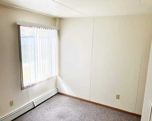 an empty room with white walls and a window