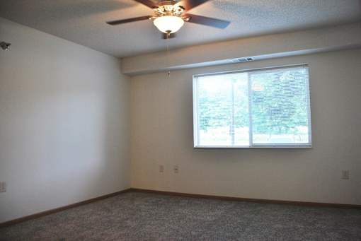 A room with a ceiling fan and a window.