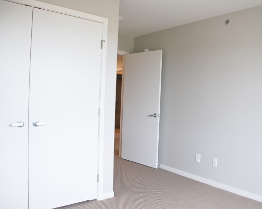 a bedroom with a white door and white walls