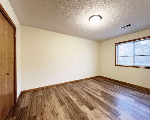A room with wooden flooring and a window.