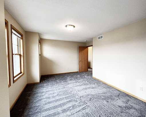 A room with a carpeted floor and a door.