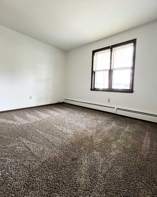 an empty room with carpet and a window