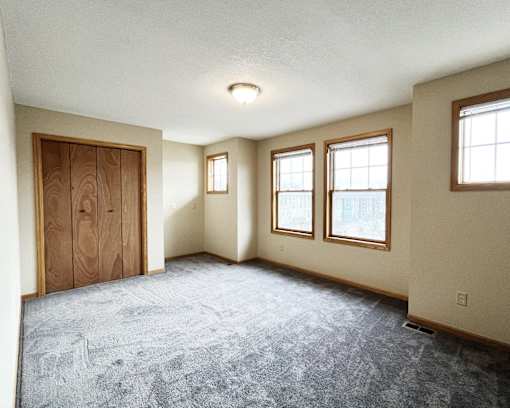 A room with a carpeted floor and a door.