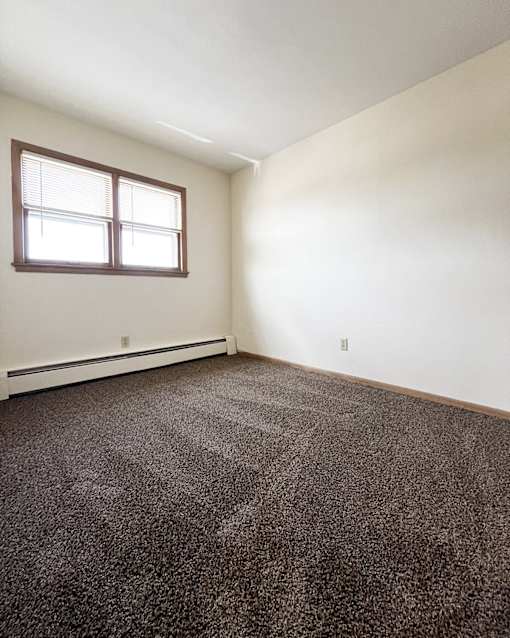 an empty room with carpet and a window