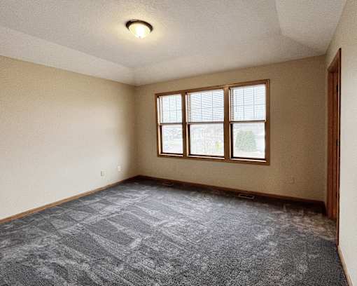 A room with a carpeted floor and a window.