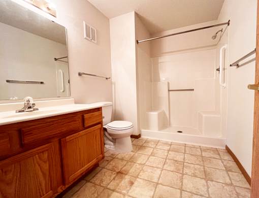 A bathroom with a toilet, sink, and shower.