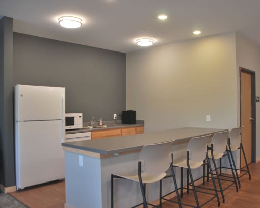 a kitchen with a counter and chairs