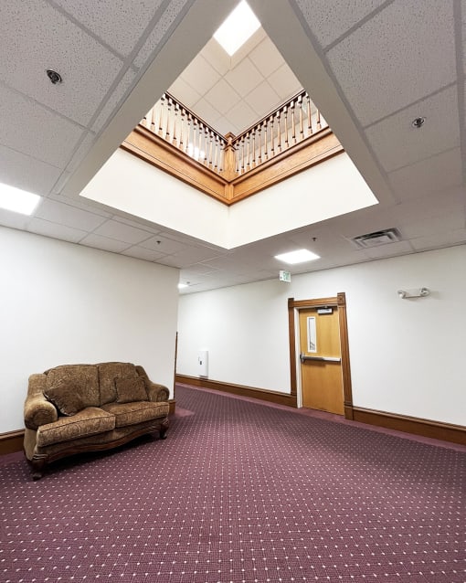 a room with a couch and a staircase in the ceiling