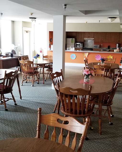 A dining room with wooden chairs and tables.