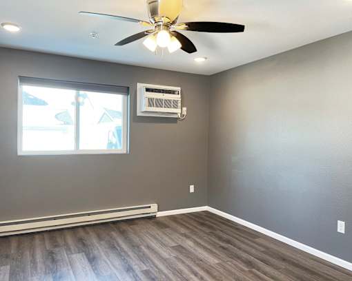 A room with a ceiling fan and a window.