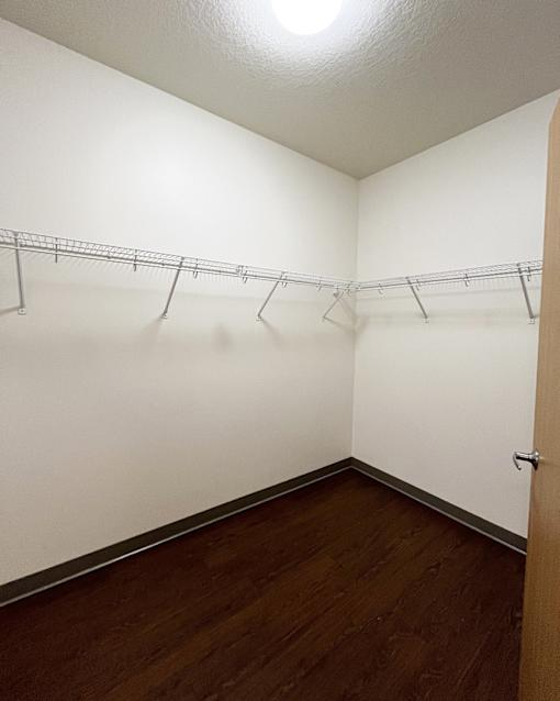 A white wall with a metal rack and a brown door.