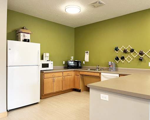 A kitchen with green walls and white appliances.