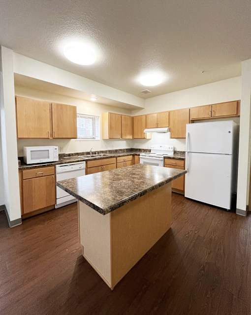 A kitchen with wooden cabinets and a granite countertop.