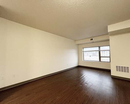 Empty room with wooden floors and a window.