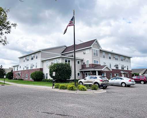A large white building with a grey roof and a flag on top.