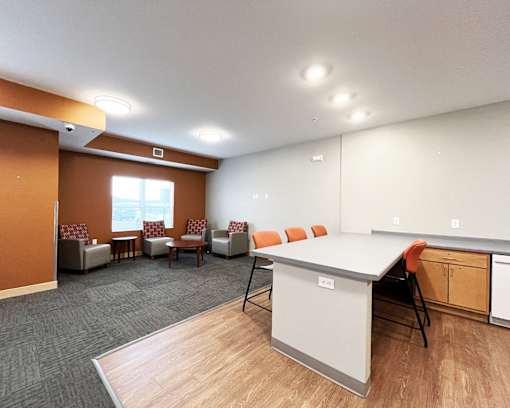 A conference room with a white table and orange chairs.