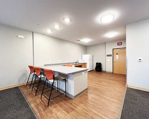 A kitchen area with a table and chairs.