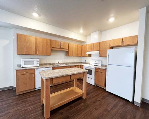 A kitchen with wooden cabinets and a white refrigerator.