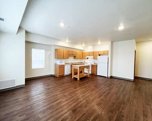A kitchen with wooden floors and white walls.