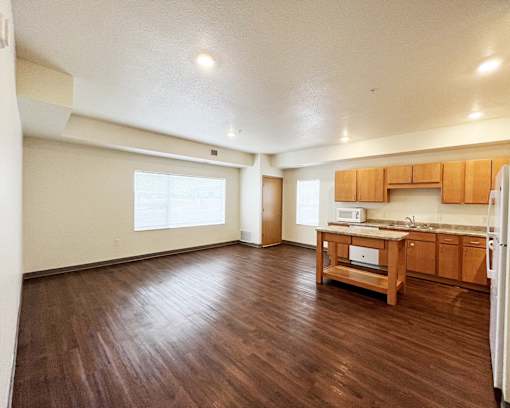 A kitchen with wooden floors and cabinets.
