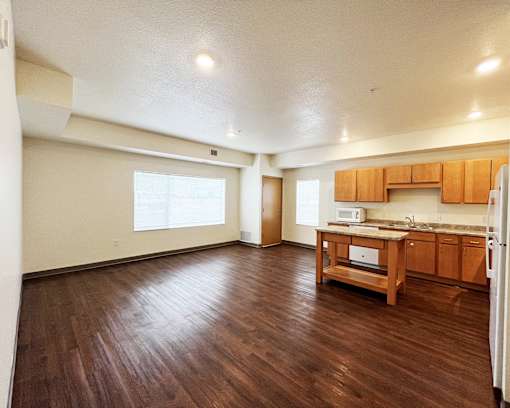 A kitchen with wooden floors and cabinets.