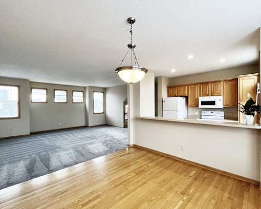 A kitchen with wooden floors and white appliances.