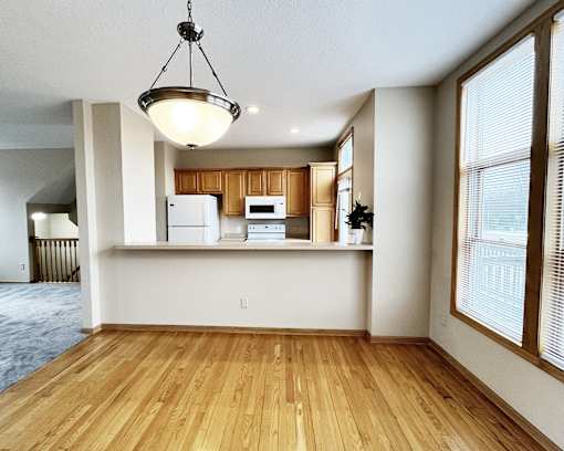 A kitchen with wooden floors and white walls.