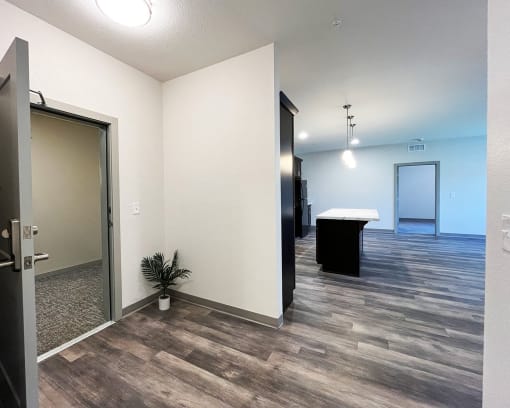 an empty hallway with a door to a room and a table