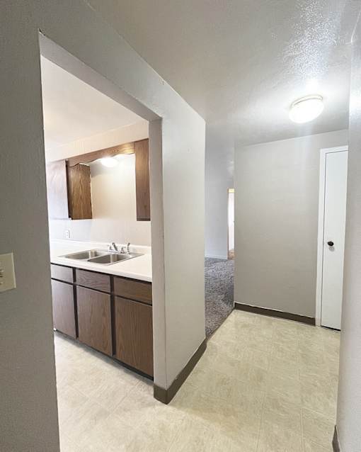 an empty kitchen with a sink and a mirror