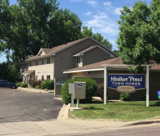 A sign for Hiniker Pond Town Homes is in front of a building.