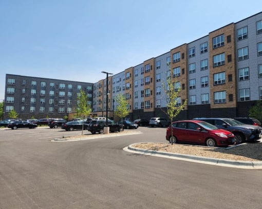 a parking lot with cars in front of a large building