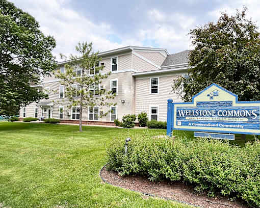 A sign for Wellstone Commons is in front of a building.