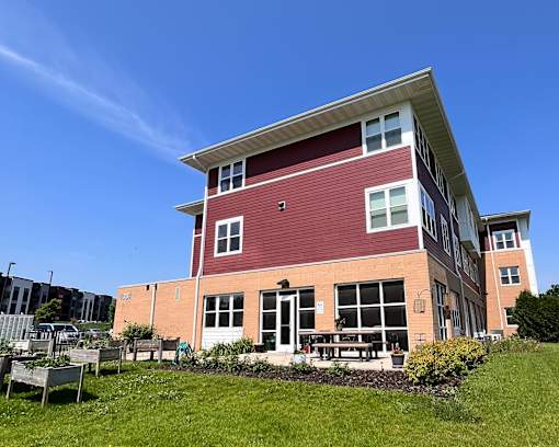 A red and white building with a green lawn in front.