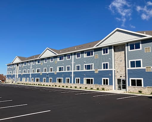 A large building with a parking lot in front.