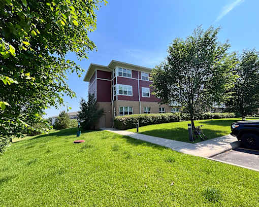 A red and white building with a green lawn in front.