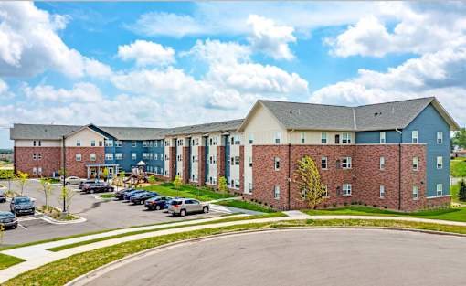 A large building with a parking lot in front.