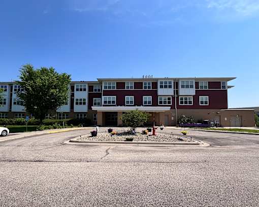 A large red and white building with a parking lot in front.